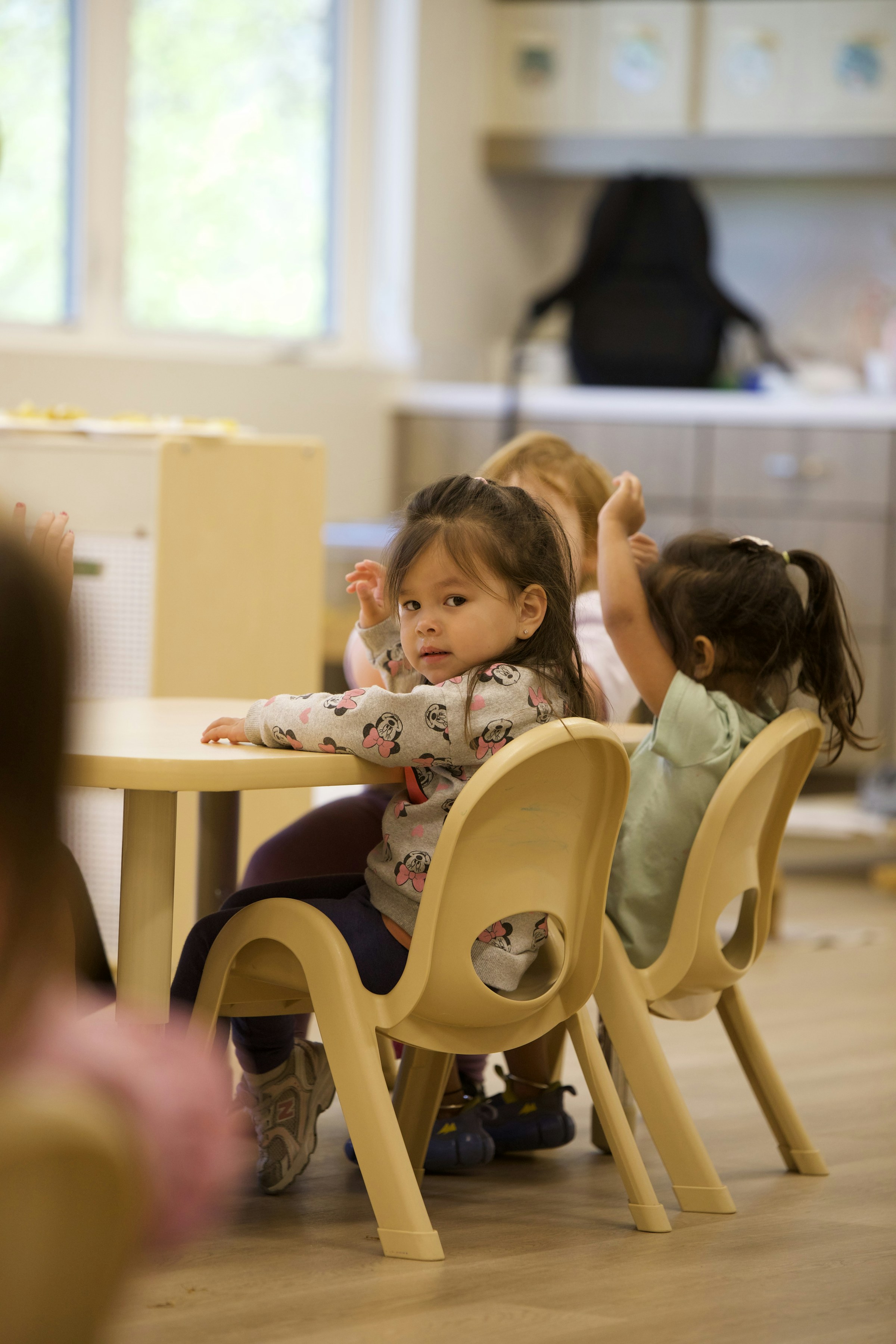 Young children sitting together at a table for group activity time